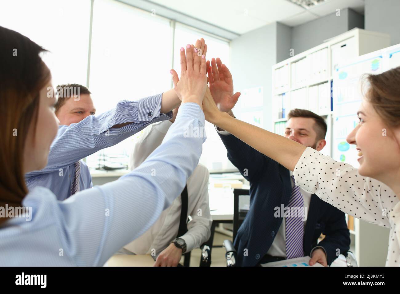 I colleghi witty che eseguono i cinque gesti alti, progetto proficuo riuscito, cambiano il futuro della società Foto Stock