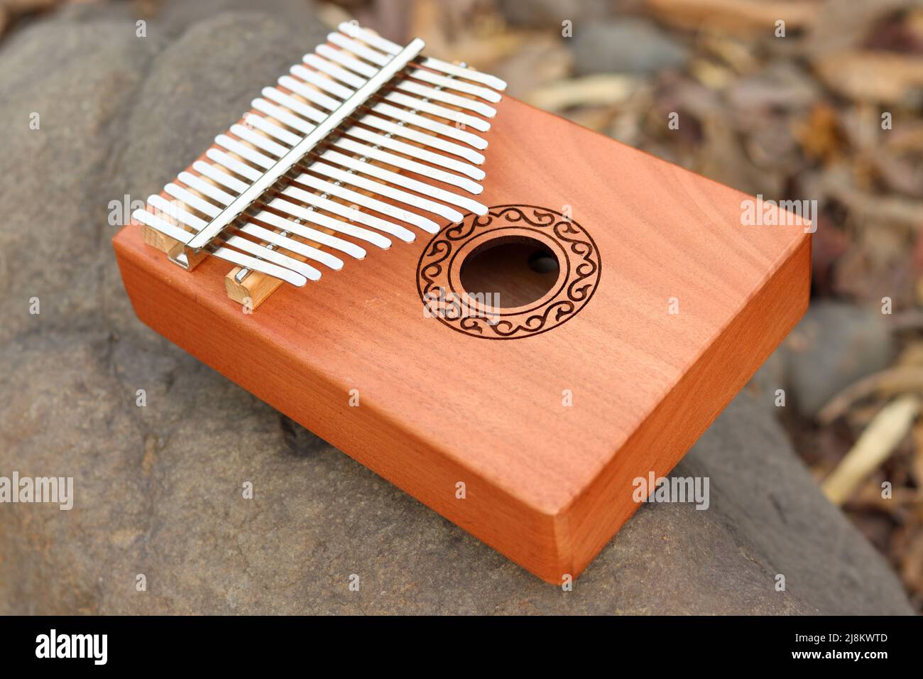 Kalimba o mano piano su pietra e foglie di fondo secco. Kalimba uno strumento musicale africano su Rock Foto Stock