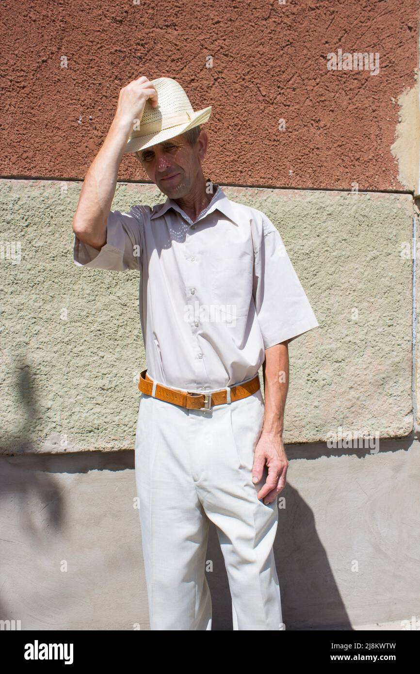 il signore anziano toglie il cappello con la mano Foto stock - Alamy