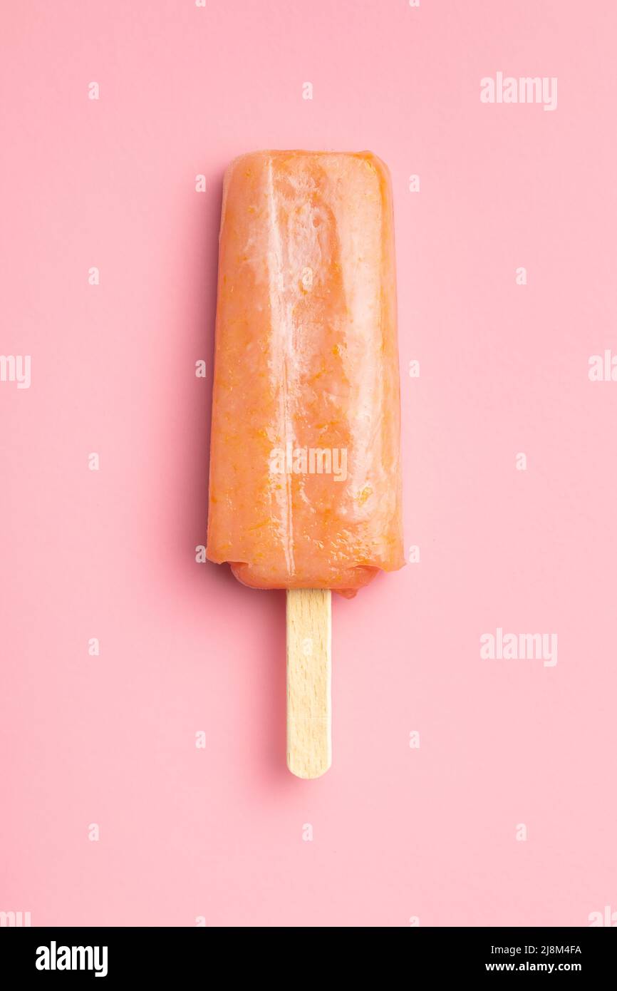 Ghiacciato fruttato. Dolce pop cicle su un tavolo rosa. Vista dall'alto. Foto Stock