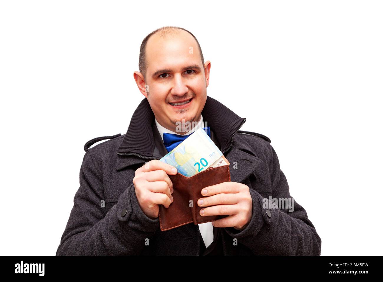 Un maschio caucasico calvo adulto ben vestito in un vestito, una camicia, una cravatta di prua e una giacca sta tenendo un portafoglio di pelle marrone da cui sta togliendo 10 e 20 Foto Stock