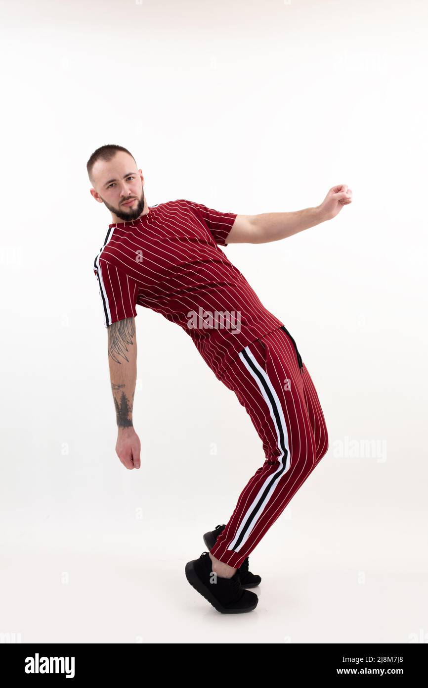 Brunetto verticale attraente uomo sicuro in posa, danza e inclinazione, deflessione. Break-dance, hip-hop, flessibile Foto Stock