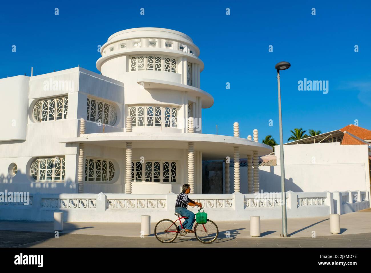 Ciclista di fronte all'edificio vicino al Malecon, Progreso, Yucatan, Messico Foto Stock