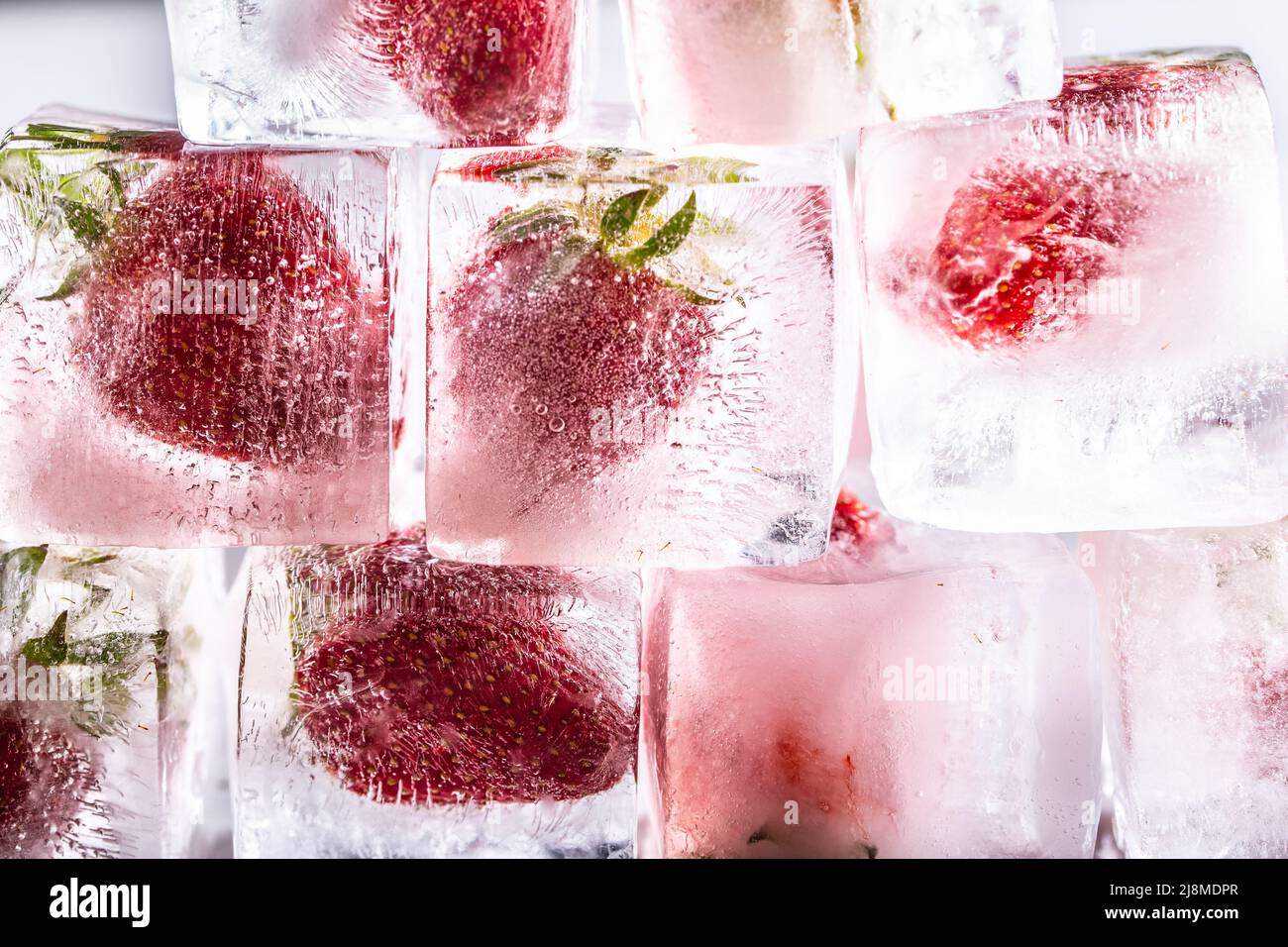 Fragole fresche congelate a cubetti di ghiaccio - primo piano. Foto Stock