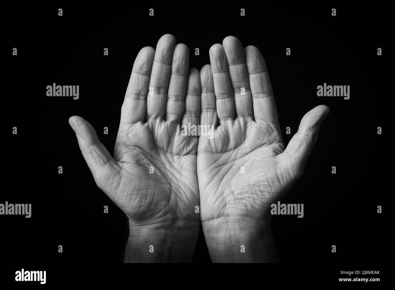 Drammatica immagine in bianco e nero di Palms Up Together emoji isolato su sfondo nero Foto Stock