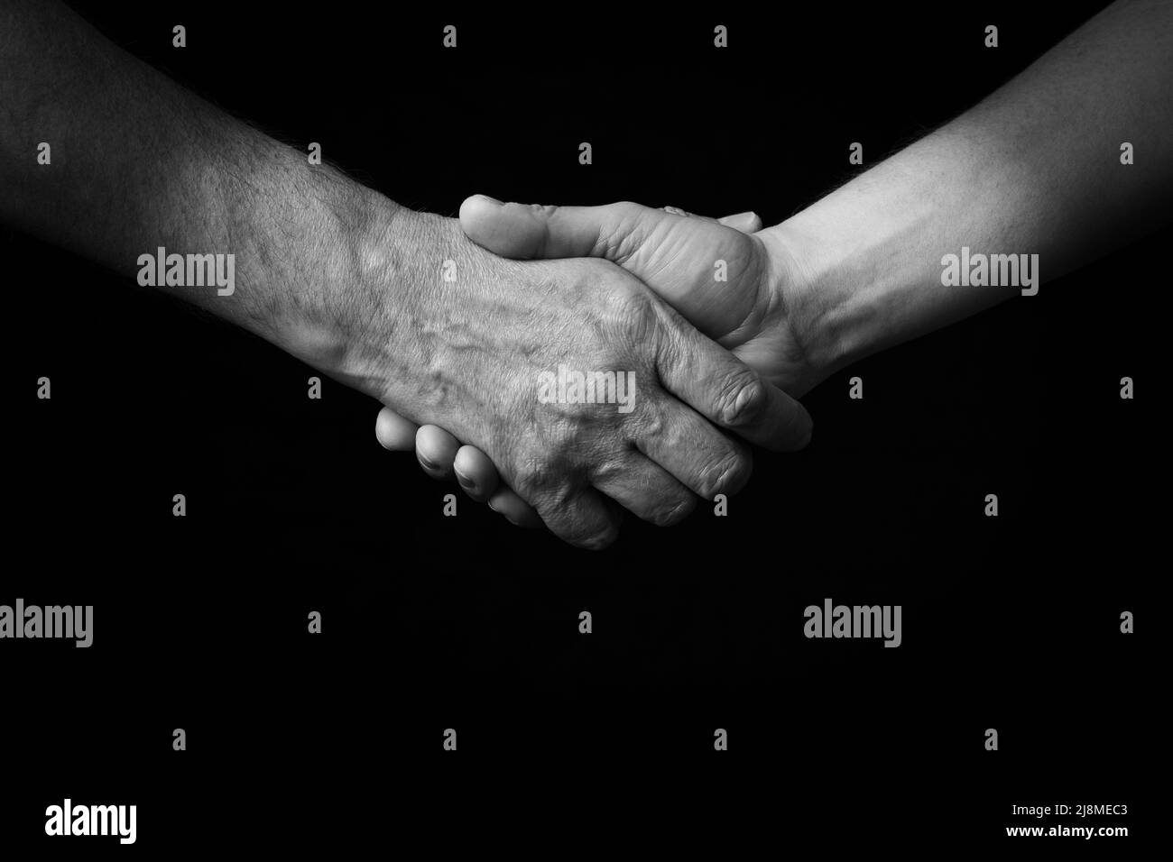 Immagine drammatica in bianco e nero di Handshake emoji isolato su sfondo nero Foto Stock