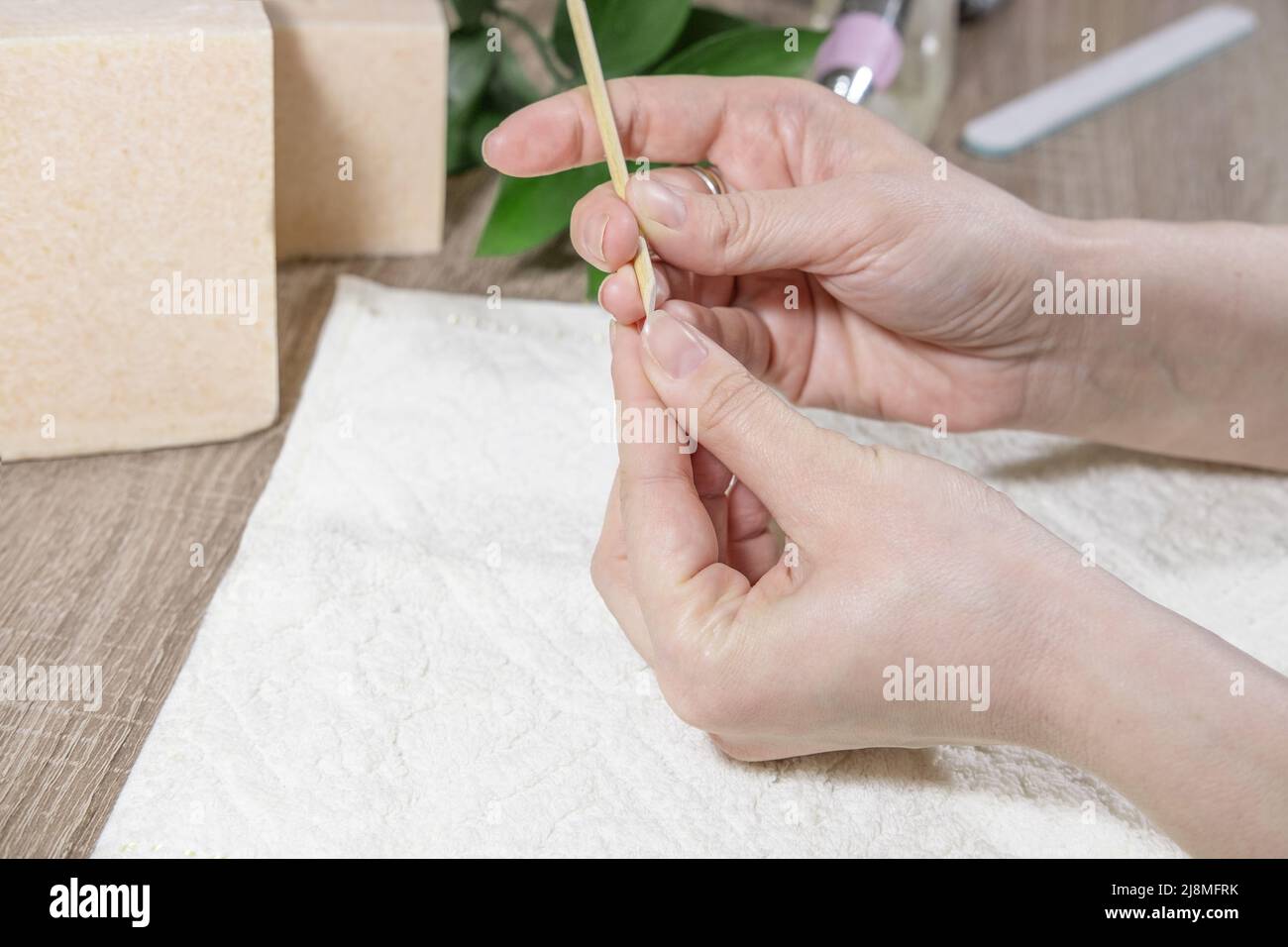 Una donna manicurista tratta le sue unghie con una lima del chiodo, lucida la superficie del chiodo, leviga la forma del chiodo in un salone di bellezza. Manicure pro Foto Stock