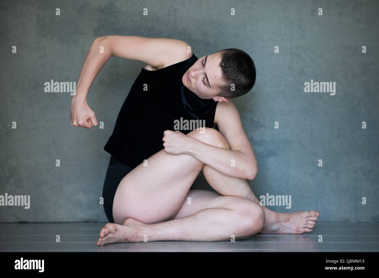 Non binario, loro / loro in posizione squat Foto Stock