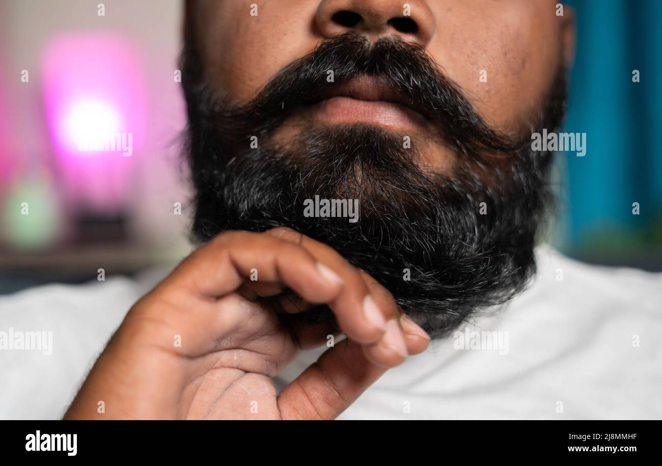 colpo irriconoscibile di uomo vestendo la barba a casa - concetto di auto-cura, cura dei capelli e cura del corpo. Foto Stock