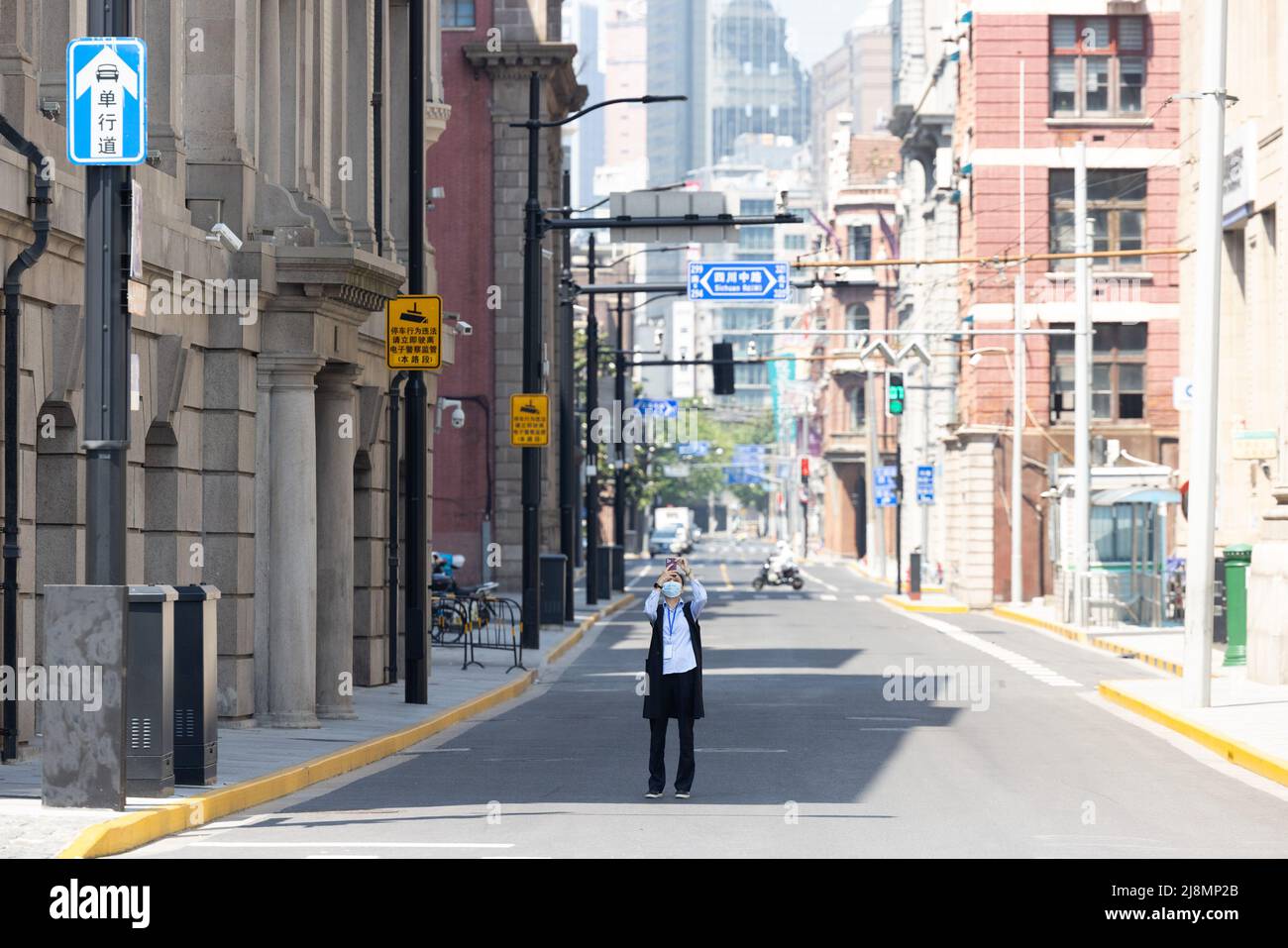 Shanghai, Cina. 17th maggio 2022. Un cittadino scatta foto su una strada a Shanghai, Cina orientale, 17 maggio 2022. Shanghai cinese ha tagliato la trasmissione comunitaria di COVID-19 in tutti i suoi 16 distretti, un funzionario comunale ha detto Martedì. Credit: Jin Liwang/Xinhua/Alamy Live News Foto Stock