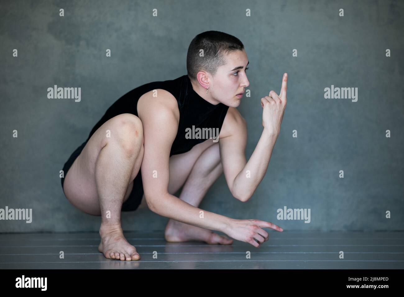 Non binario, loro / loro in posizione squat Foto Stock