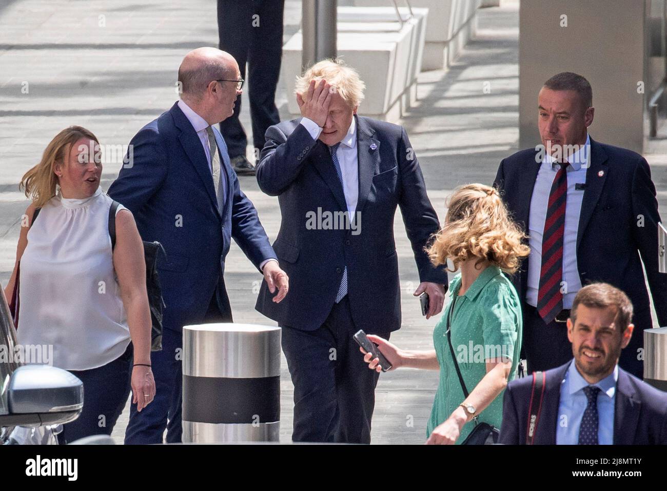 Londra - 17/05/2022. Il primo Ministro Boris Johnson è visto con la mano sulla testa mentre lascia l'apertura della nuova Elizabeth Line a cui ha partecipato Foto Stock