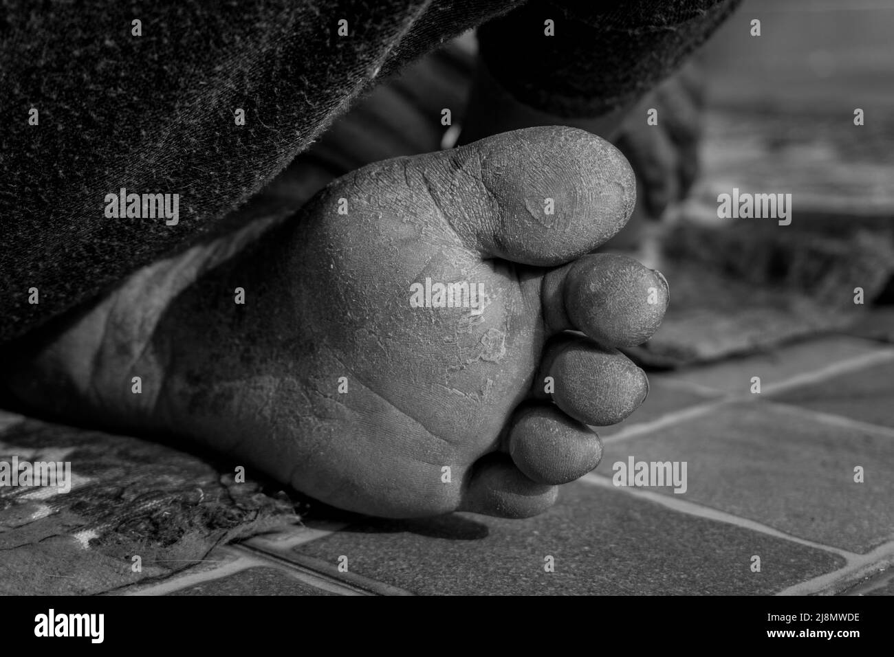 Un primo colpo di piedi ruvidi di una donna anziana in India in bianco e nero. Foto Stock