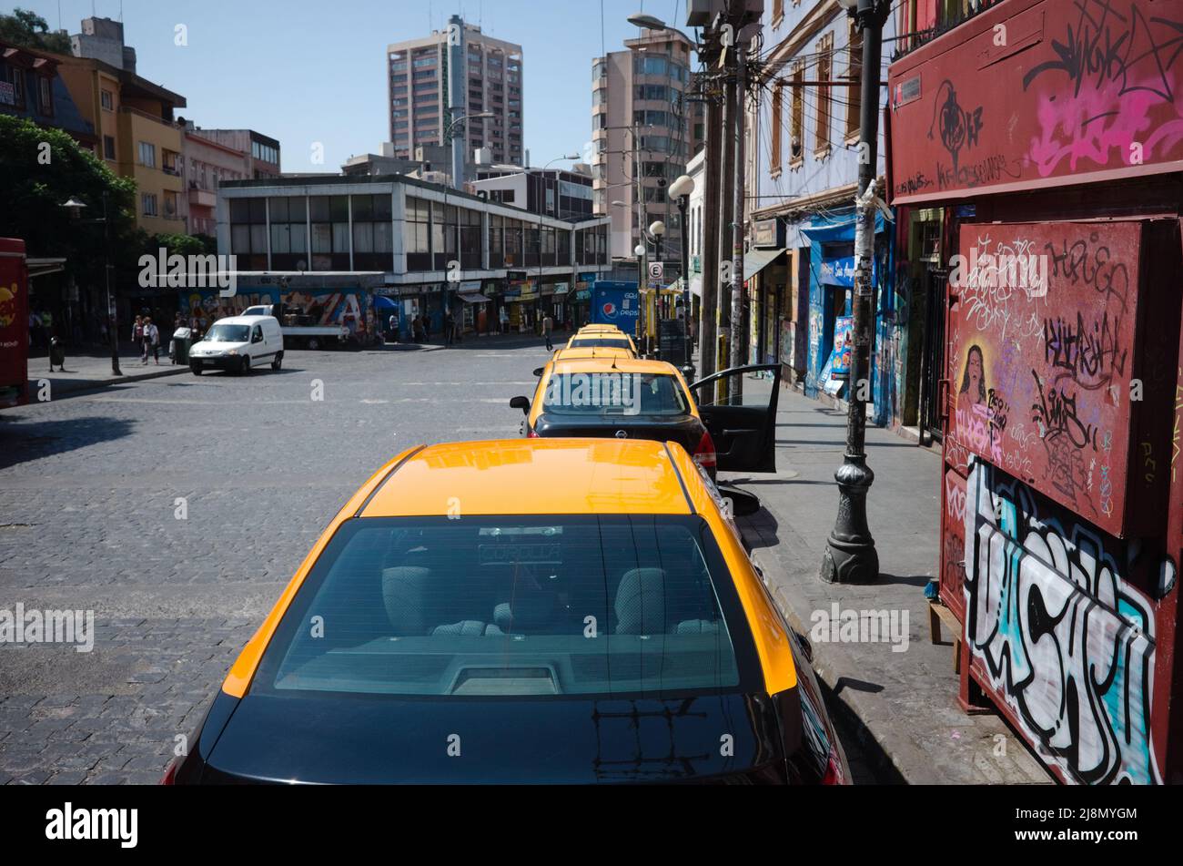 Valparaiso, Cile - Febbraio, 2020: Taxi con tetti gialli parcheggiati in fila lungo Avenida Ecuador strada nel quartiere Bellavista. Fila di taxi della città parcheggiata Foto Stock