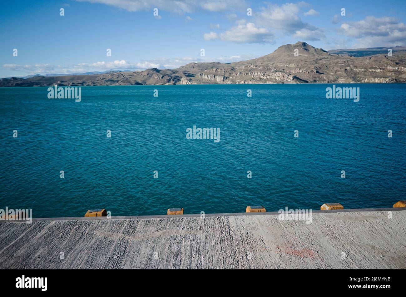Vista delle montagne dal molo sul Lago generale Carrera, Puerto Ibanez, Provincia di Aysen, Cile. Giorno d'estate al lago glaciale con wate blu chiaro e brillante Foto Stock
