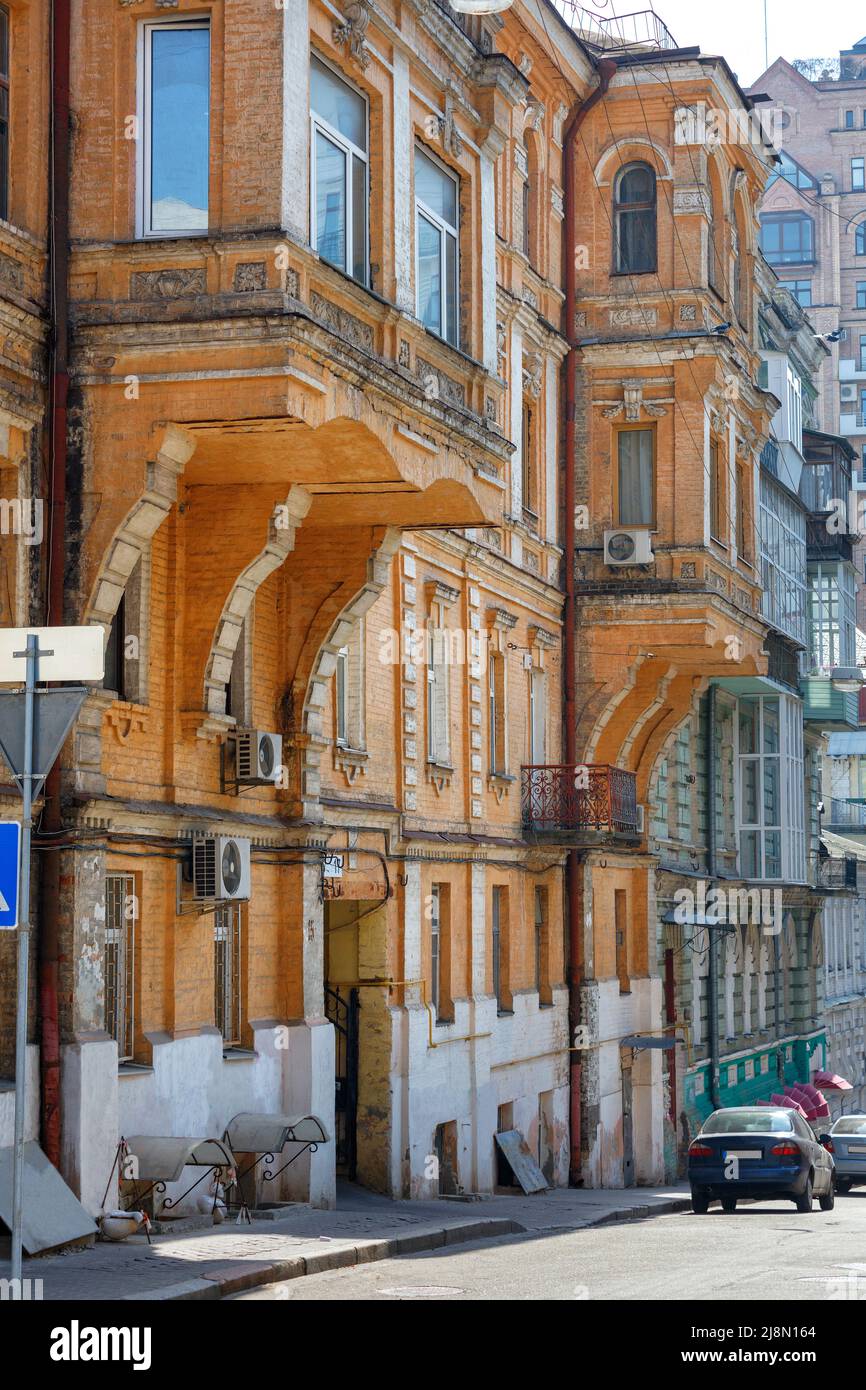 Archi di balcone sulla facciata di un vecchio edificio all'ombra di una stretta strada della città. Foto Stock