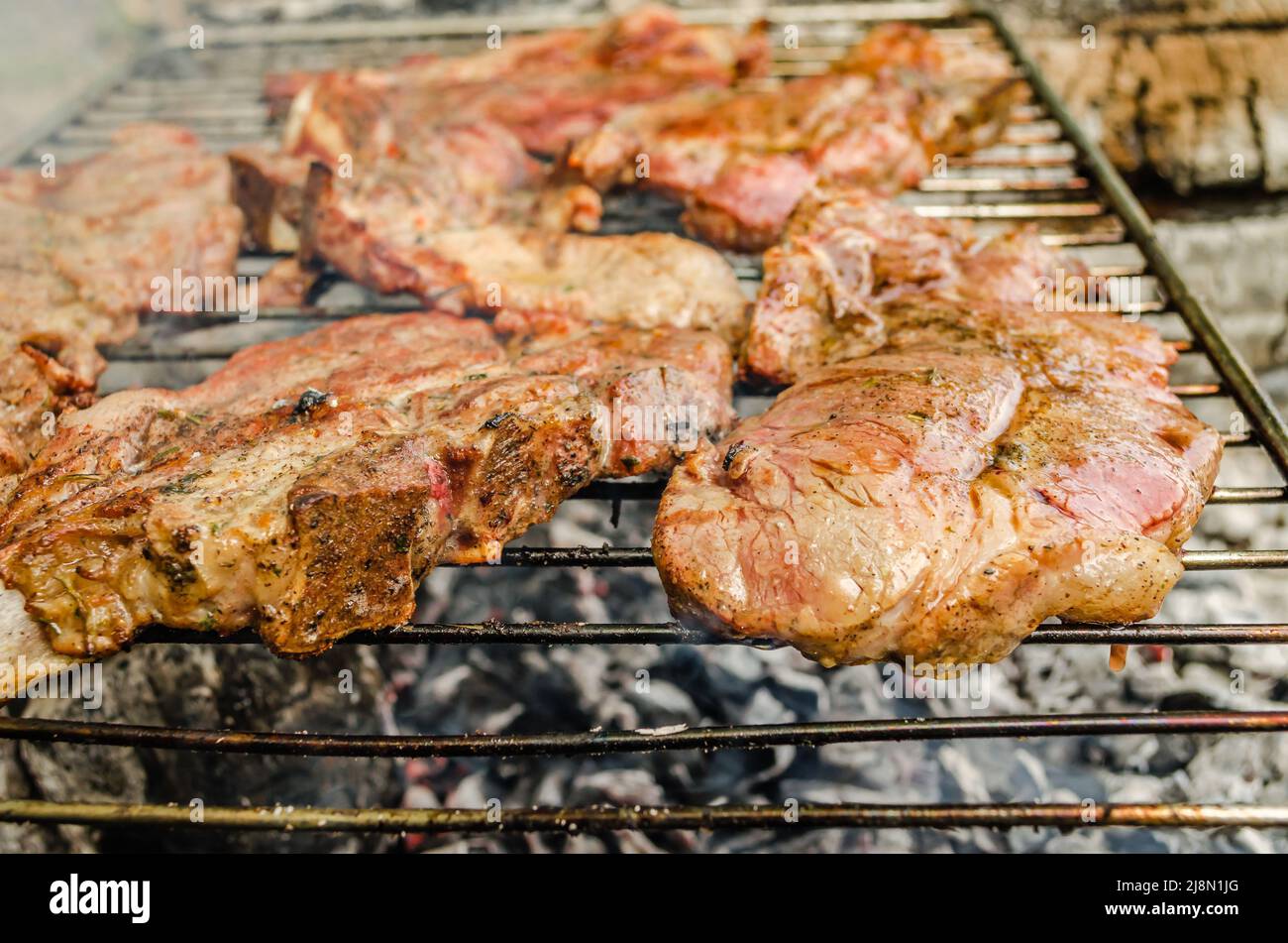 Carne per cibo - filetto di maiale su una griglia estiva con una fiamma. Foto Stock