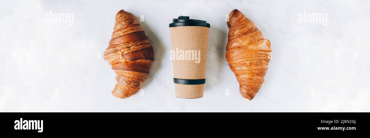 Croissant con caffè per andare in eco tazza, take away colazione banner. Disposizione piatta, visualizzazione njp, spazio di copia Foto Stock