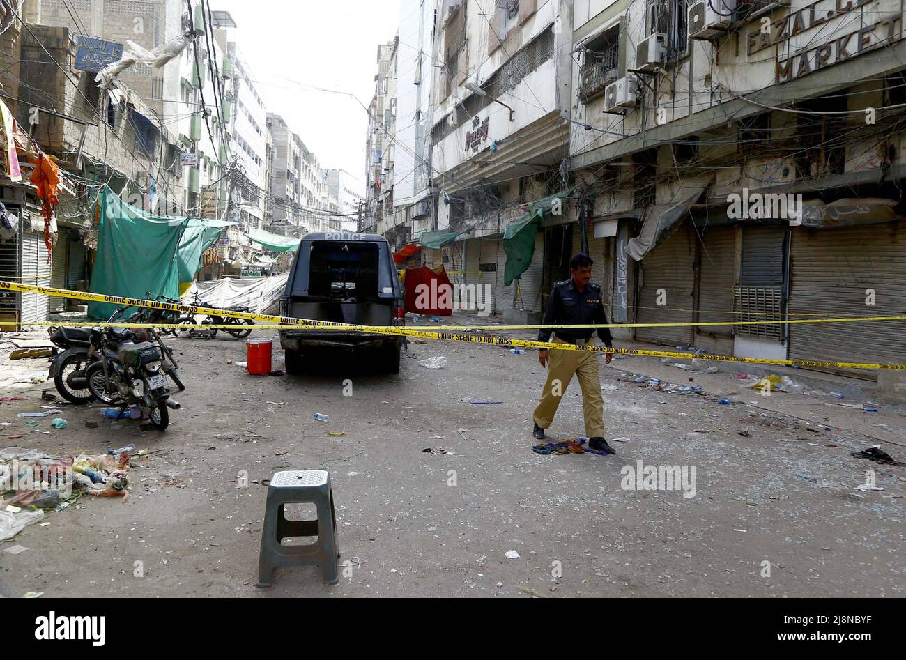 La vista di follow-up del luogo mentre i funzionari di sicurezza sono Cordon fuori del luogo per l'ispezione è in corso dopo l'esplosione della bomba piantata la scorsa notte situata nella zona del mercato di Kharadar Bolton di Karachi martedì 17 maggio 2022. Almeno una donna è stata uccisa e circa una dozzina di persone sono rimaste ferite dopo che si è verificata un'esplosione al mercato di Bolton a Kharadar, affollato da Karachi. I funzionari hanno detto che un veicolo di polizia era l'obiettivo dato che tre poliziotti, tra cui un sub-ispettore assistente (ASI), hanno subito lesioni quando un dispositivo esplosivo improvvisato (IED), piantato in una motocicletta, è stato detonato vicino al mobile Foto Stock