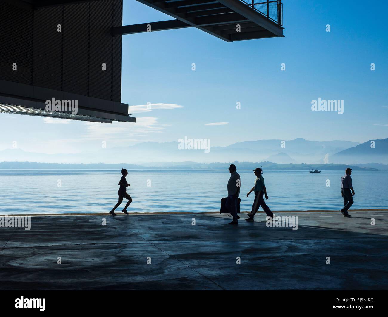 Persone che camminano lungo il molo del porto di Santander sotto la struttura metallica del Botin Centre. Foto Stock