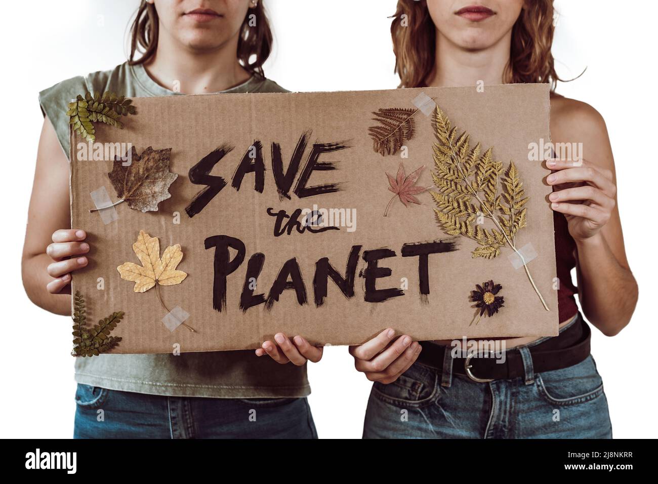 Due giovani attivisti femminili che tengono un cartone con il messaggio "salvare il pianeta", foglie e fiori Foto Stock
