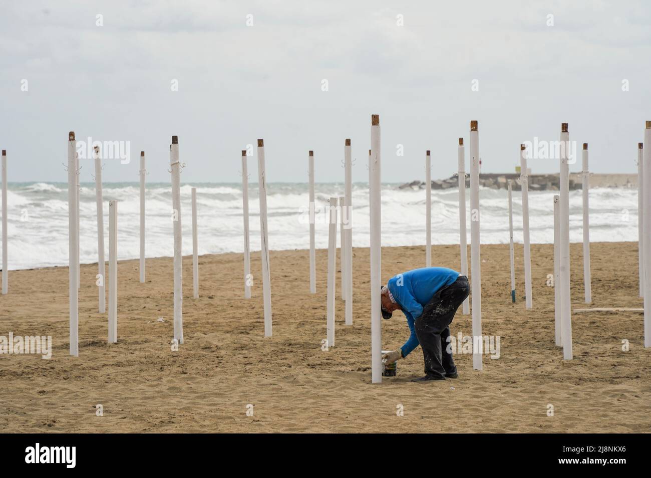 Uomo che prepara ombrelloni per la nuova stagione dopo pandemia, Costa del Sol. Foto Stock