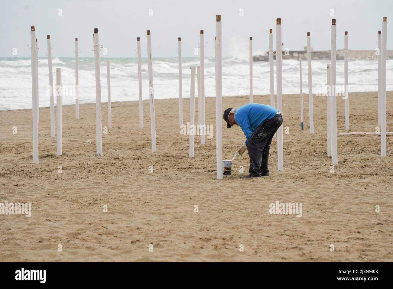 Uomo che prepara ombrelloni per la nuova stagione dopo pandemia, Costa del Sol. Foto Stock