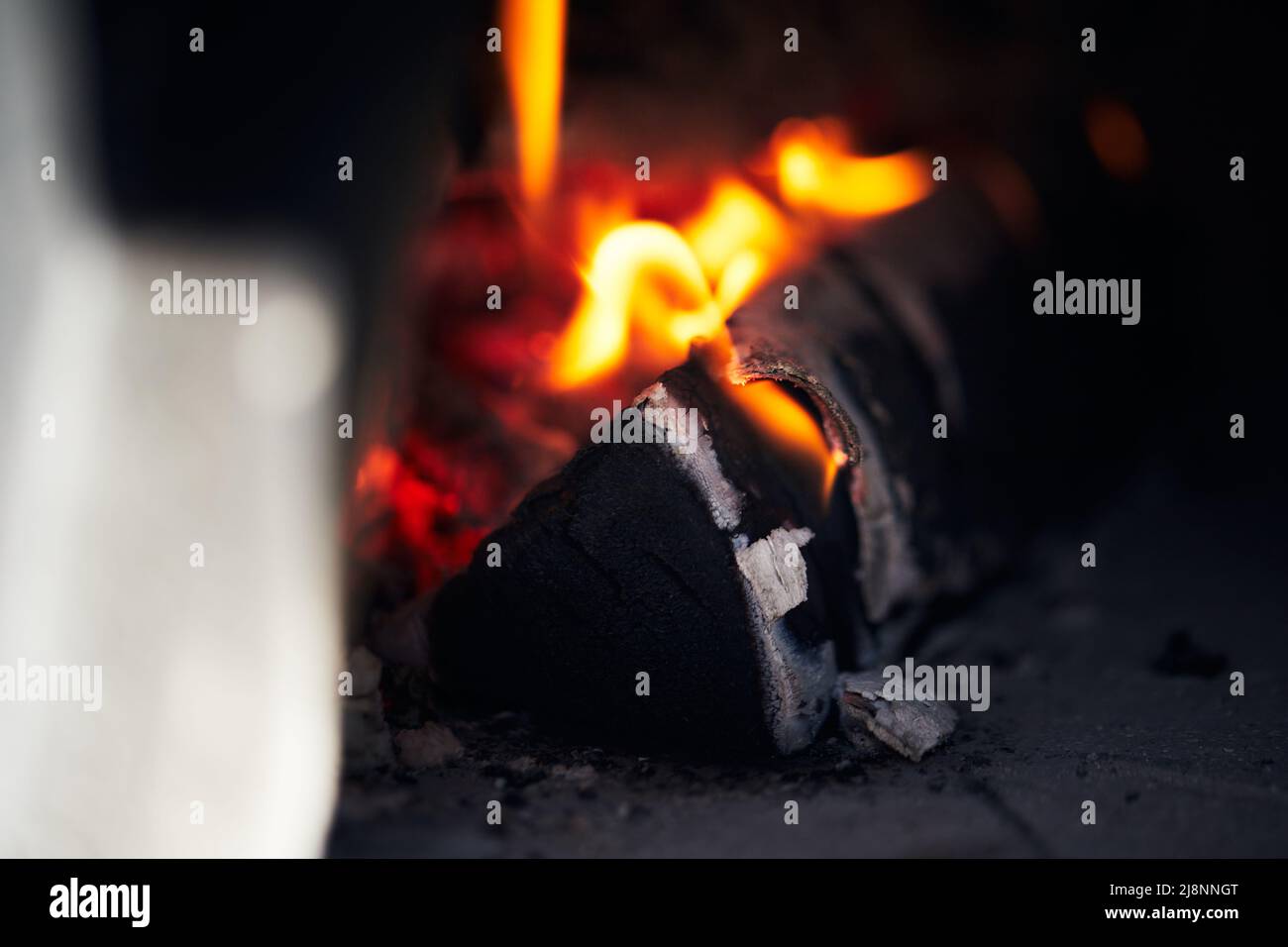 Forno a legna per pizza con tronchi di betulla per l'accensione. Il fuoco  brucia e il forno si riscalda. Vista frontale Foto stock - Alamy