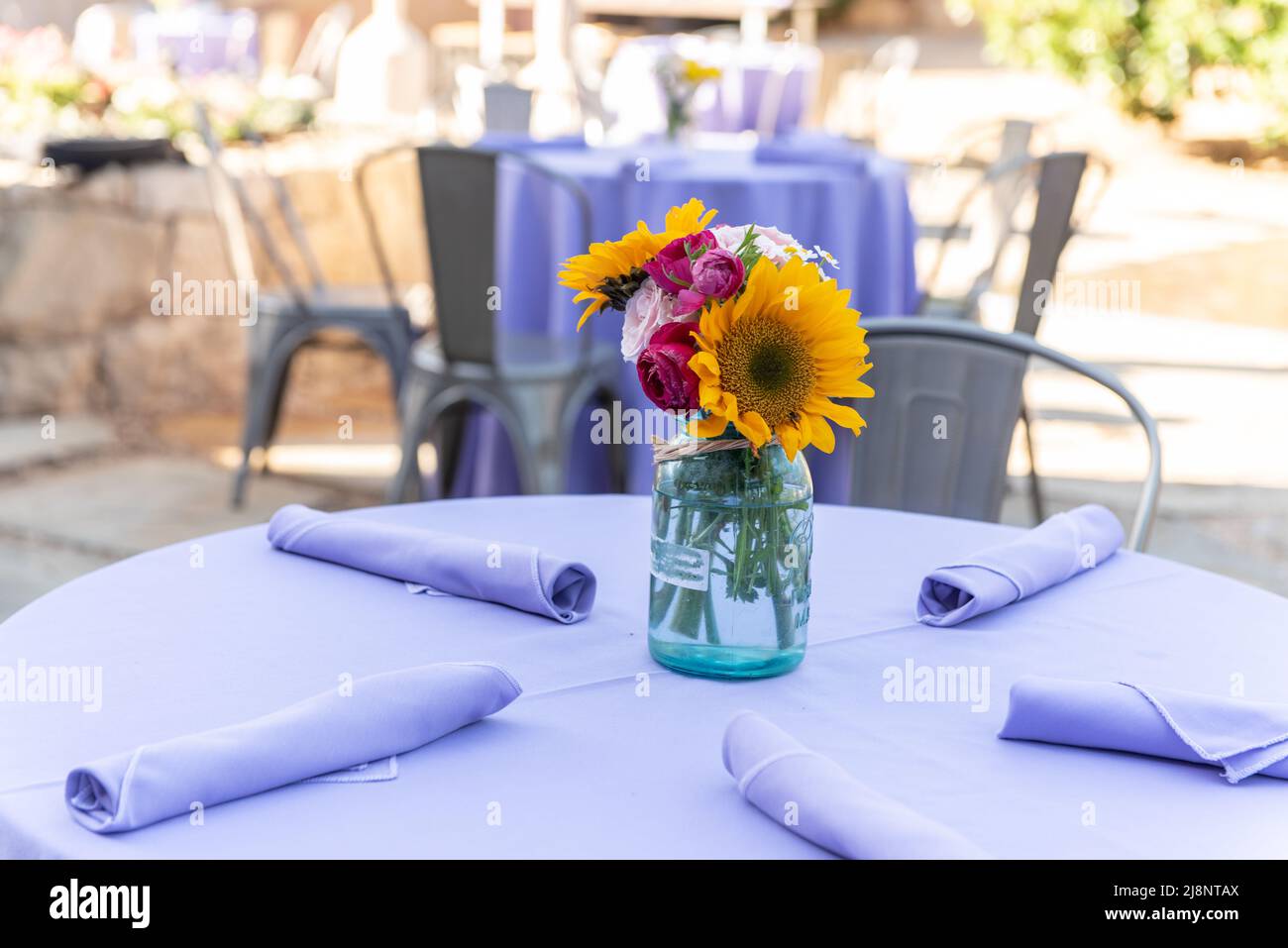 Girasoli in vaso decorare il tavolo da festa perfettamente per quattro ospiti. Foto Stock