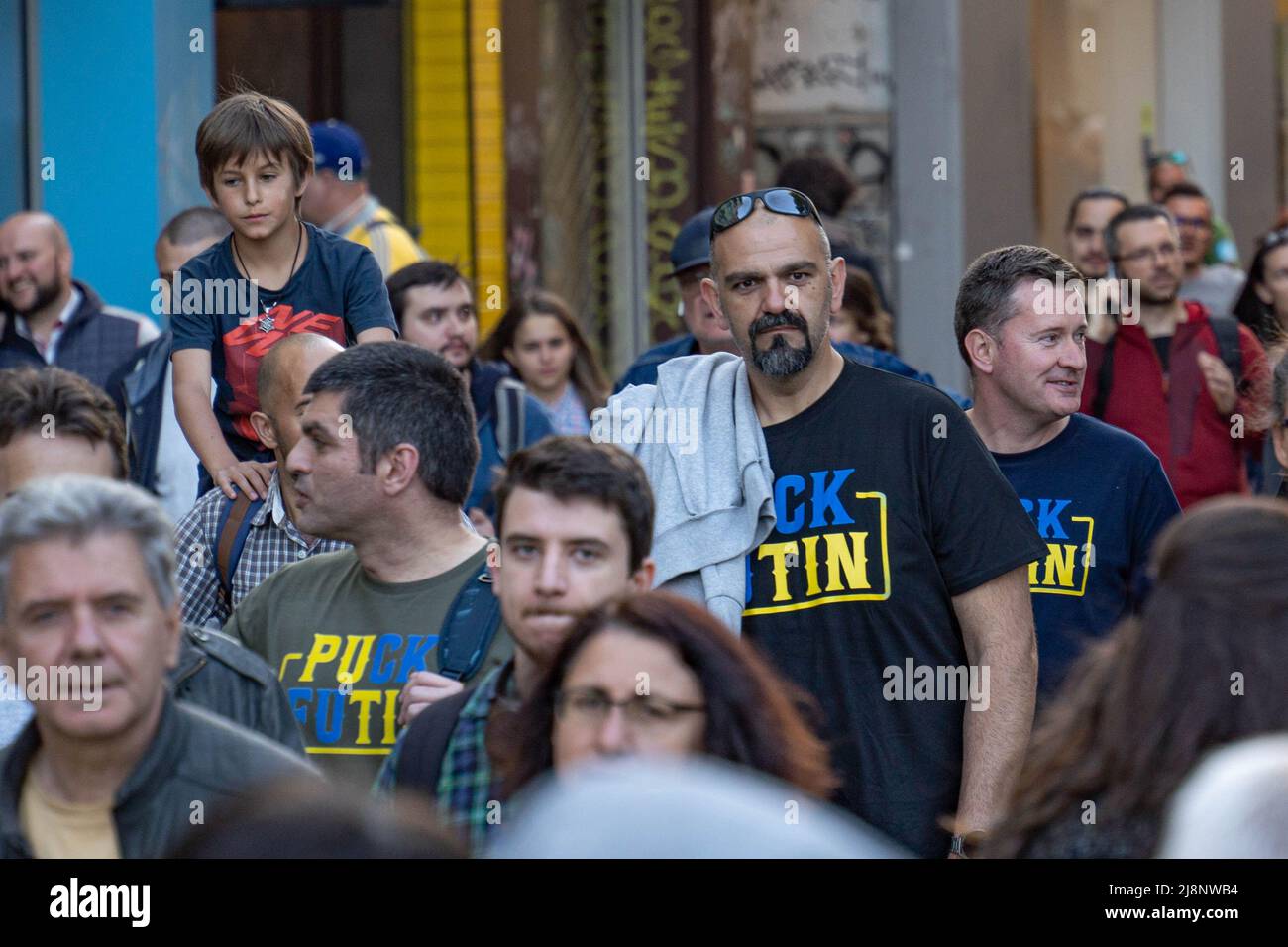 Sofia, Bulgaria - 09 maggio 2022: Tre uomini di mezza età dall'aspetto artistico, vestiti in magliette Puck Futin camminano nella folla per strada Foto Stock