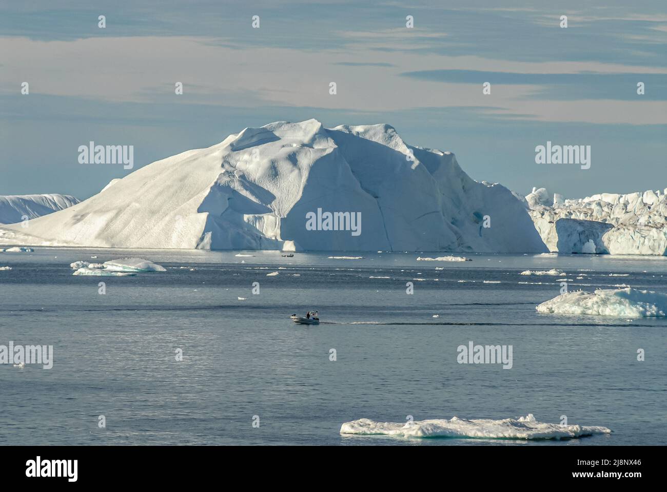 Piccola barca da pesca tra iceberg nella baia di Disko, Groenlandia, Danimarca Foto Stock