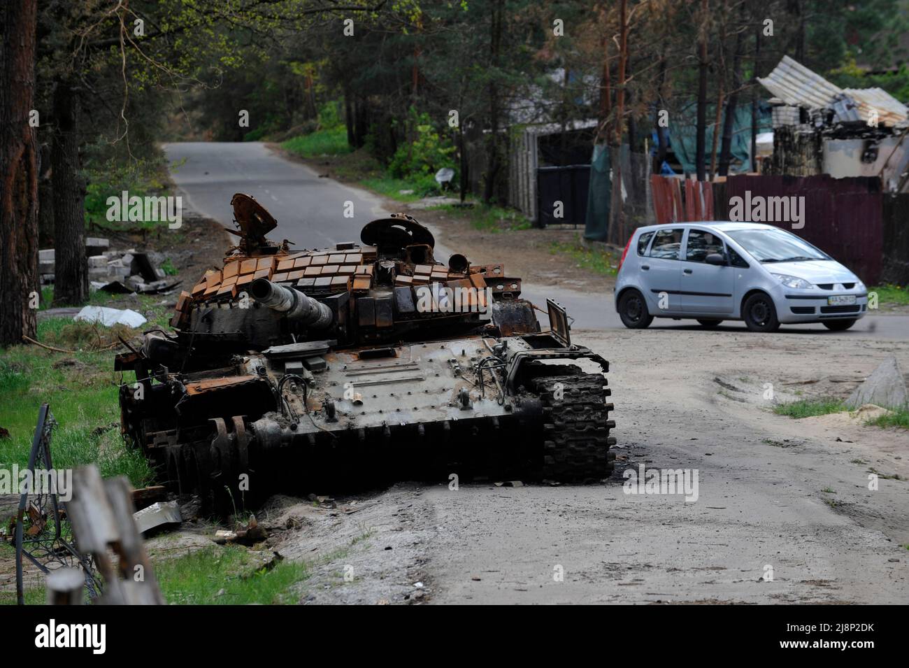 Mykolaivka, Ucraina. 17th maggio 2022. Un'auto passa davanti a un carro armato distrutto dell'esercito russo nel villaggio di Mykolaivka nella regione di Kyiv. La Russia ha invaso l'Ucraina il 24 febbraio 2022, scatenando il più grande attacco militare in Europa dalla seconda guerra mondiale (Credit Image: © Sergei Chuzavkov/SOPA Images via ZUMA Press Wire) Foto Stock