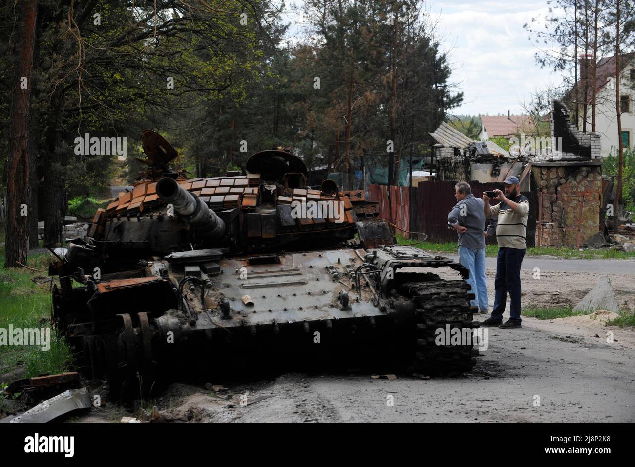 Mykolaivka, Ucraina. 17th maggio 2022. Un uomo scatta una foto di un carro armato distrutto dell'esercito russo nel villaggio di Mykolaivka nella regione di Kyiv. La Russia ha invaso l'Ucraina il 24 febbraio 2022, scatenando il più grande attacco militare in Europa dalla seconda guerra mondiale (Credit Image: © Sergei Chuzavkov/SOPA Images via ZUMA Press Wire) Foto Stock