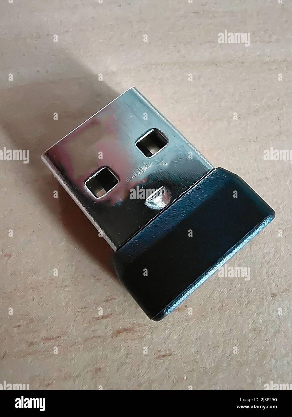 Connettore USB per un mouse per computer wireless in primo piano su una superficie di legno Foto Stock