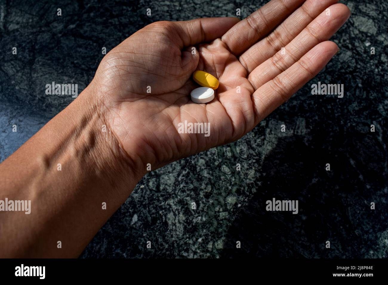 Persona paziente che consuma farmaci prescritti compresse in mano. Foto Stock