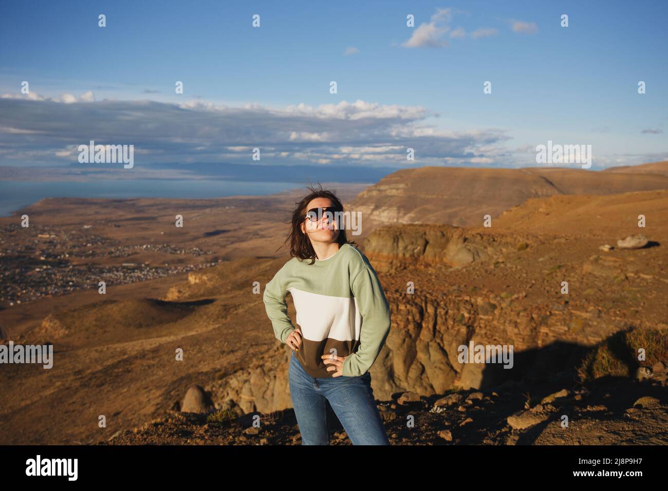 Ragazza in occhiali da sole sul ponte di osservazione in montagna Foto Stock