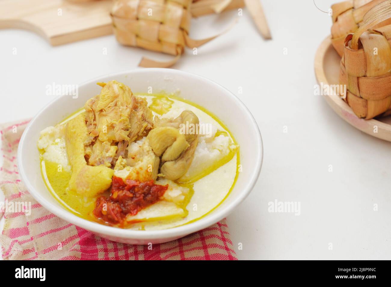 L'Opor Ayam viene servito su sfondo bianco. L'Opor è un tradizionale cibo indonesiano a base di pollo cotto con salsa al latte di cocco Foto Stock