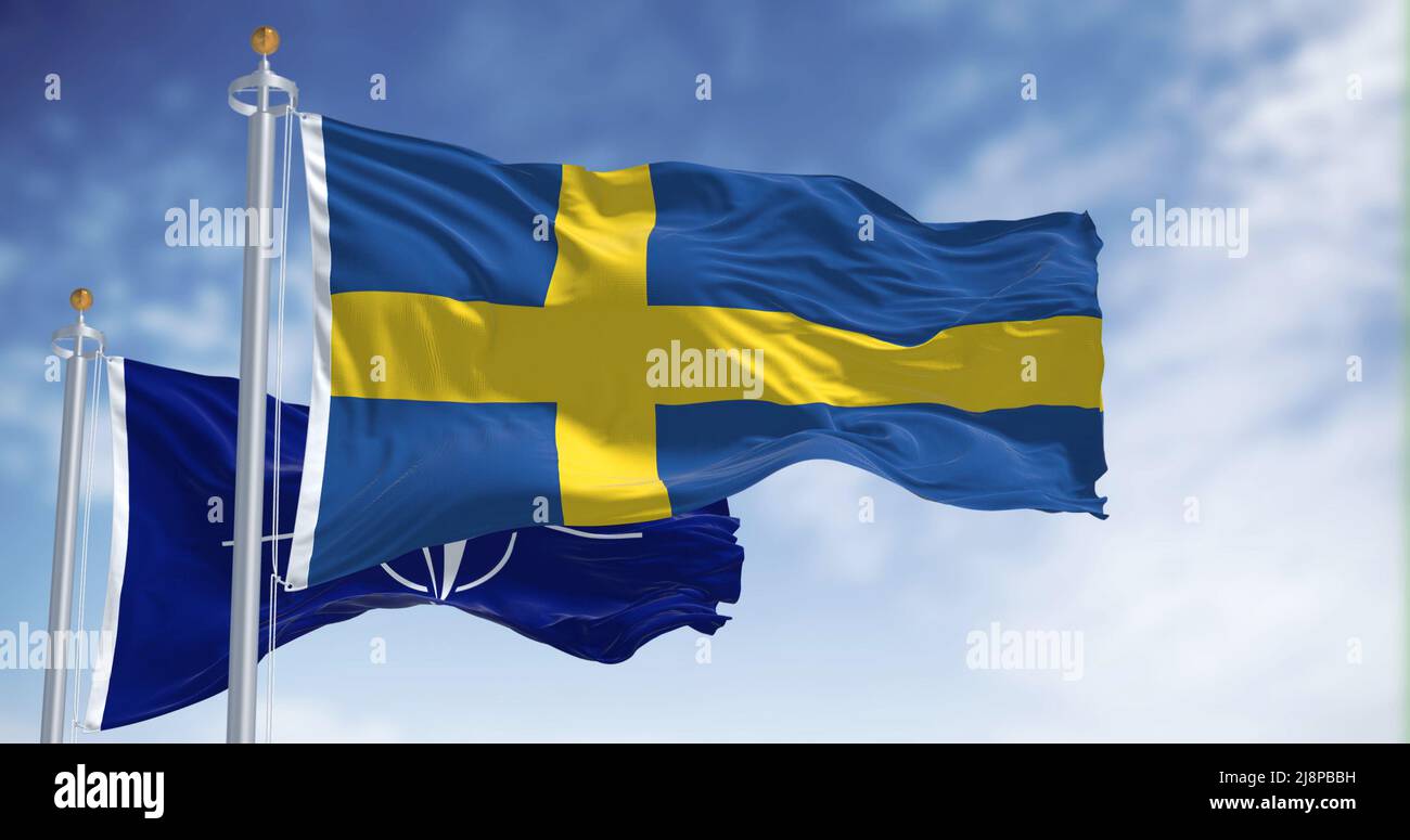 Stoccolma, Svezia, maggio 2022: La bandiera nazionale della Finlandia sventola insieme alla bandiera della NATO. Nel 2022 la Svezia chiese di aderire alla NATO dopo decenni di neutr Foto Stock