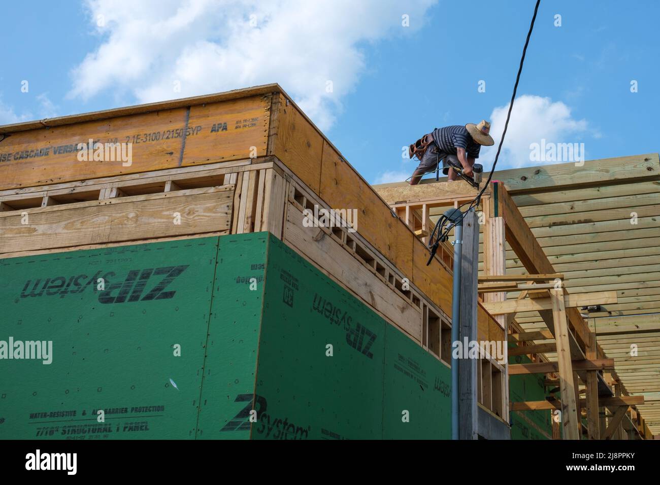 NEW ORLEANS, LA, Stati Uniti d'America - 17 maggio 2022: Lavoratore che usa la pistola durante la costruzione della casa nel quartiere Uptown Foto Stock