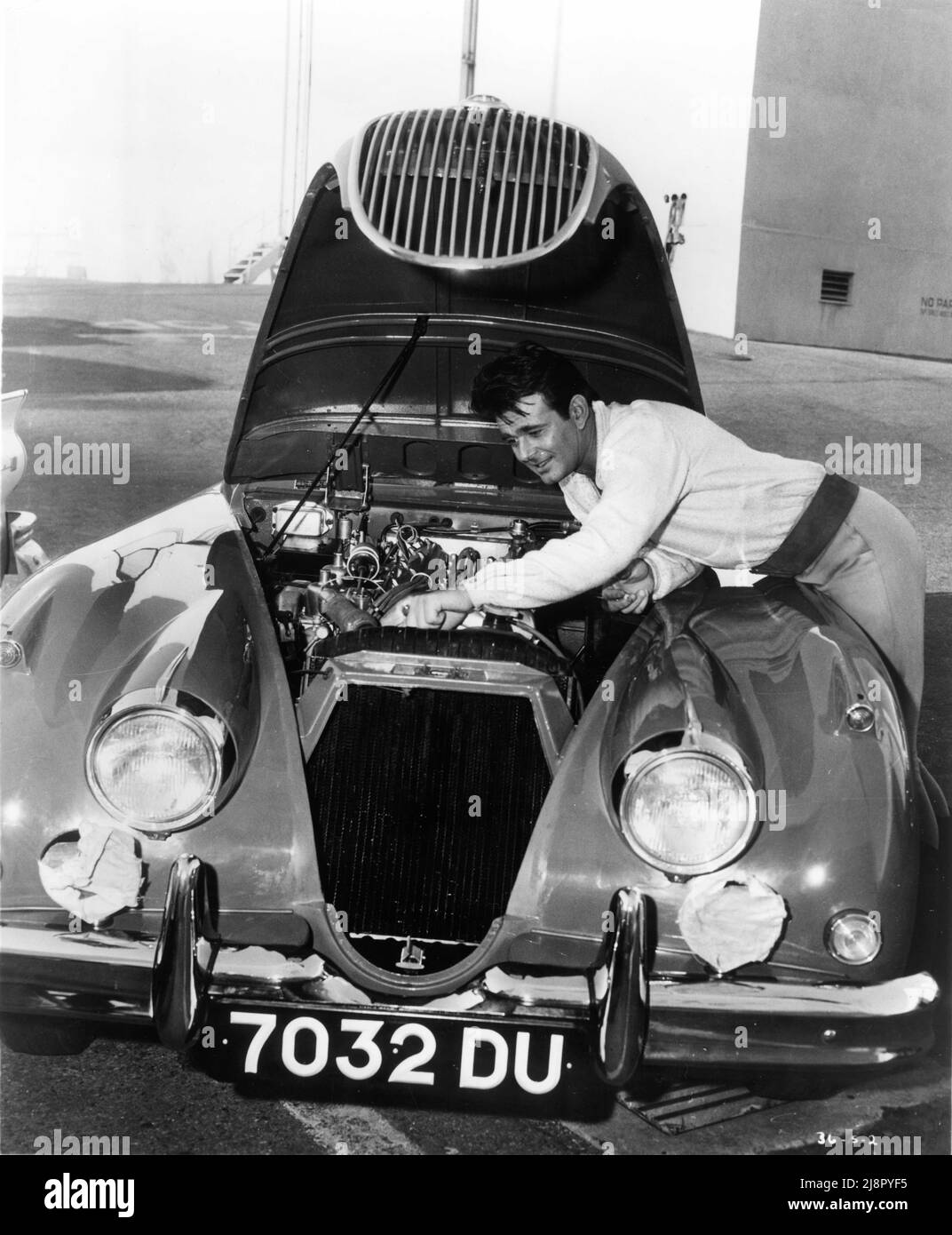 STUART WHITMAN 1961 candid ritratto sul 20th secolo Fox Studios Lot tinkering con il motore della sua Sport Car pubblicità per il 20 ° secolo Fox Foto Stock