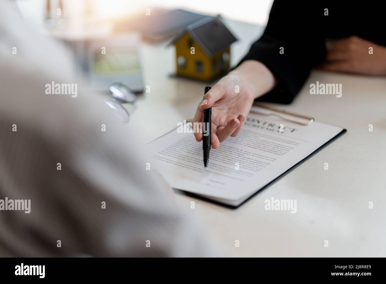 L'agente immobiliare sta spiegando lo stile della casa ai clienti che vengono a contatto per vedere il disegno della casa e l'accordo di acquisto Foto Stock