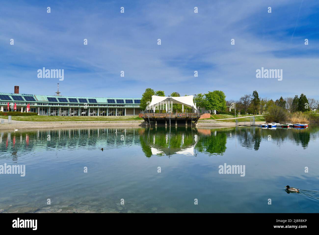 Friburgo, Germania - Aprile 2022: Parco pubblico chiamato 'Seegpark' con lago con piccolo palco all'aperto Foto Stock