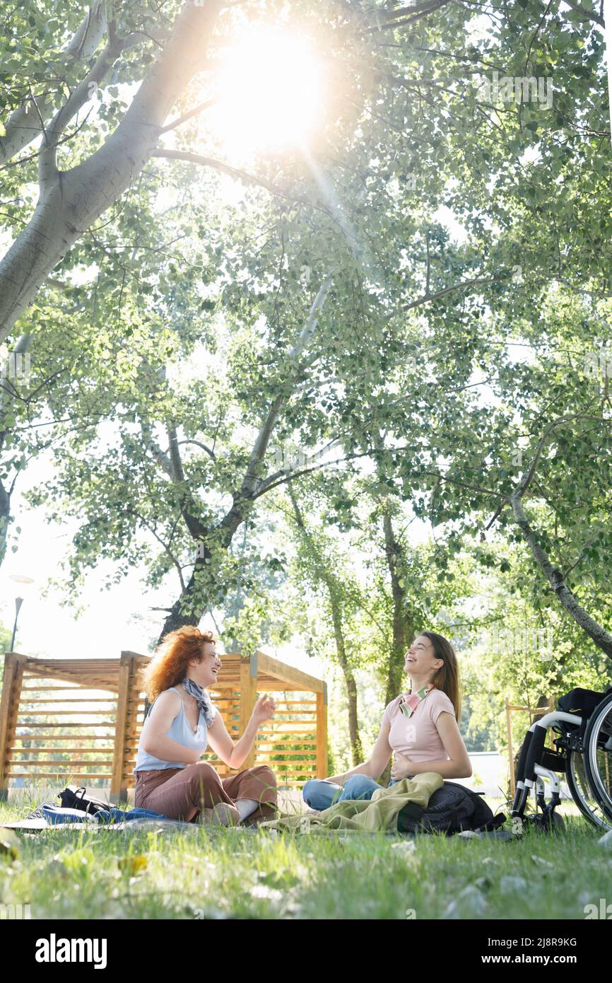Due amici che ridono insieme in un parco in una bella giornata estiva Foto Stock