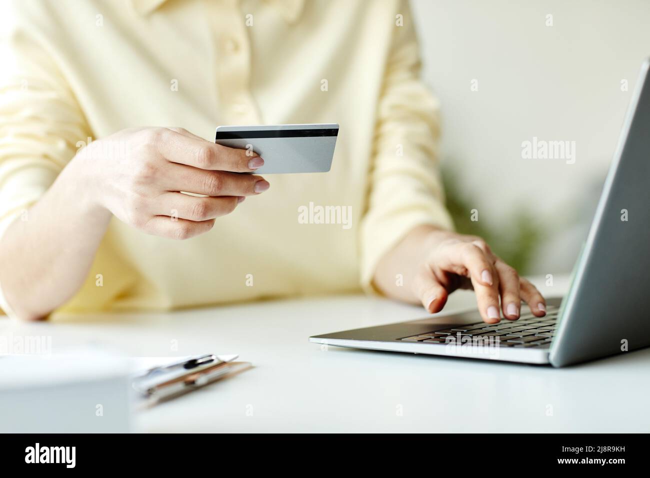 Donna irriconoscibile che acquista qualcosa nel negozio online su laptop che paga gli articoli con carta di credito Foto Stock