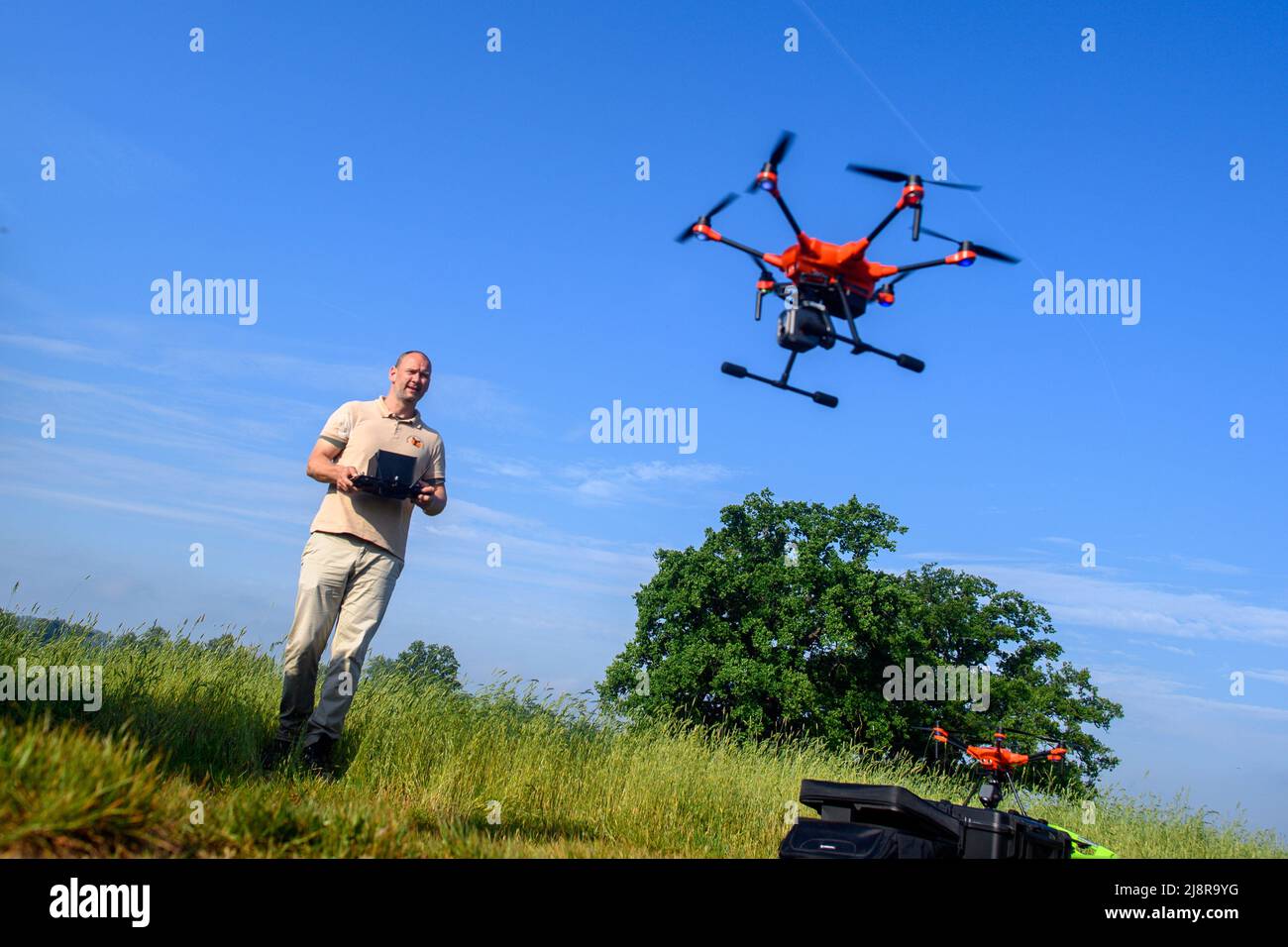 18 maggio 2022, Sassonia-Anhalt, Ranies: Wilko Florstedt dell'associazione 'Wildtierretter Sachsen-Anhalt' lancia un drone con una termocamera ai margini di un campo per la ricerca di fawns. I soccorritori della fauna selvatica in Sassonia-Anhalt stanno proteggendo le faine dai pericoli del haymaking ancora quest'anno. L'associazione è ora sulla strada nello Stato con cinque droni. I droni sono dotati di termocamere e potrebbero così rilevare i fawns che si trovano nell'erba. I soccorritori recuperano i fawns in scatole dal campo in cui trascorrono il tempo di falciatura. I fawns sono deposti in erba alta a poppa Foto Stock