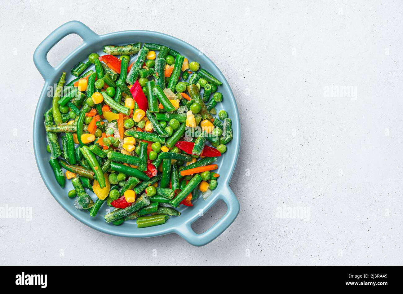 Un mix di verdure surgelate su sfondo grigio con spazio da copiare. Foto Stock