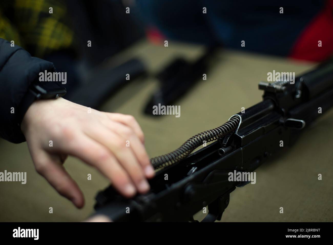 Assemblaggio del fucile d'assalto AK 47. Armi da fuoco Kalashnikov fucile d'assalto. La gente sta raccogliendo la pistola dummy. Addestramento militare. Foto Stock
