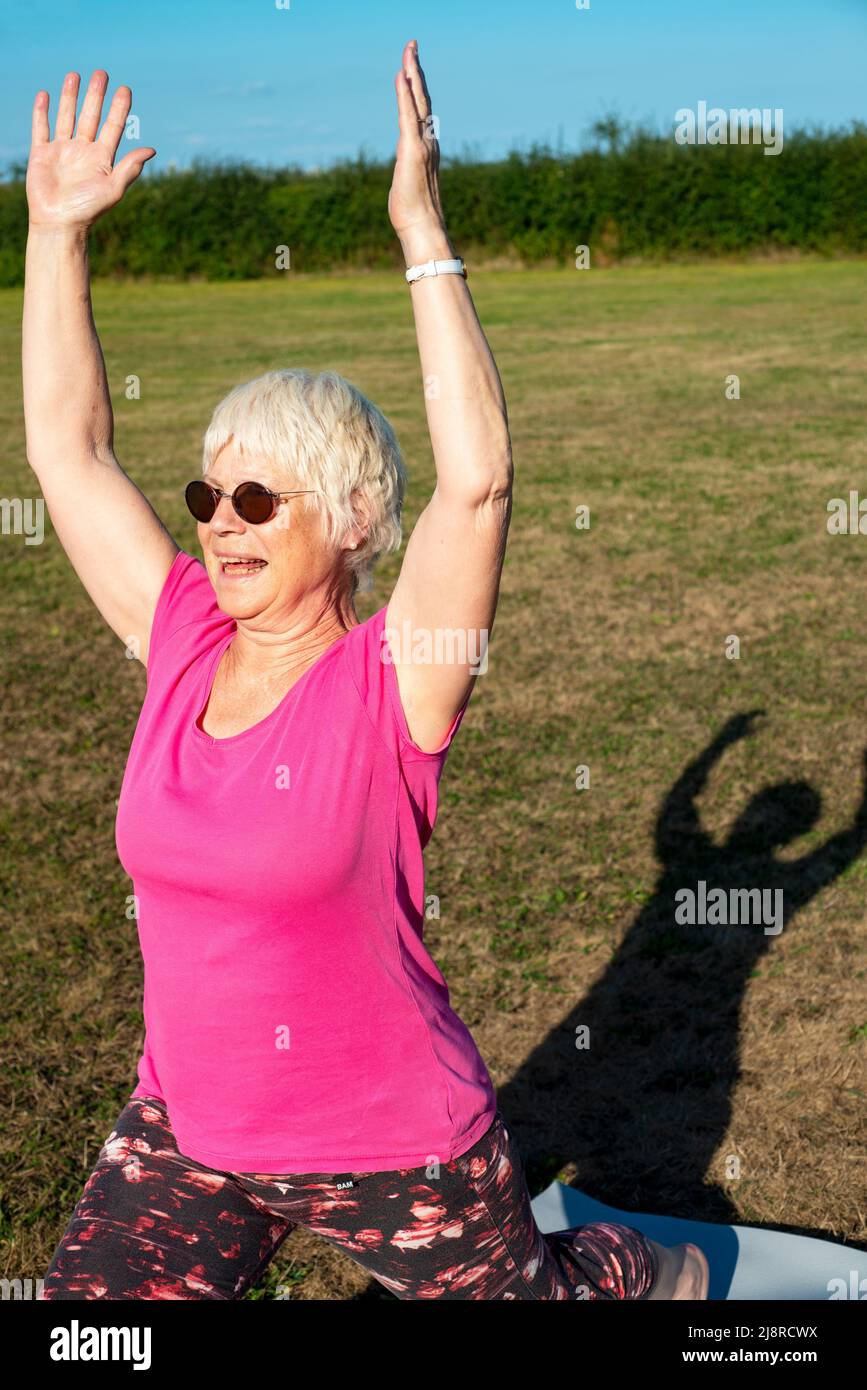 Donna anziana che esegue yoga Foto Stock