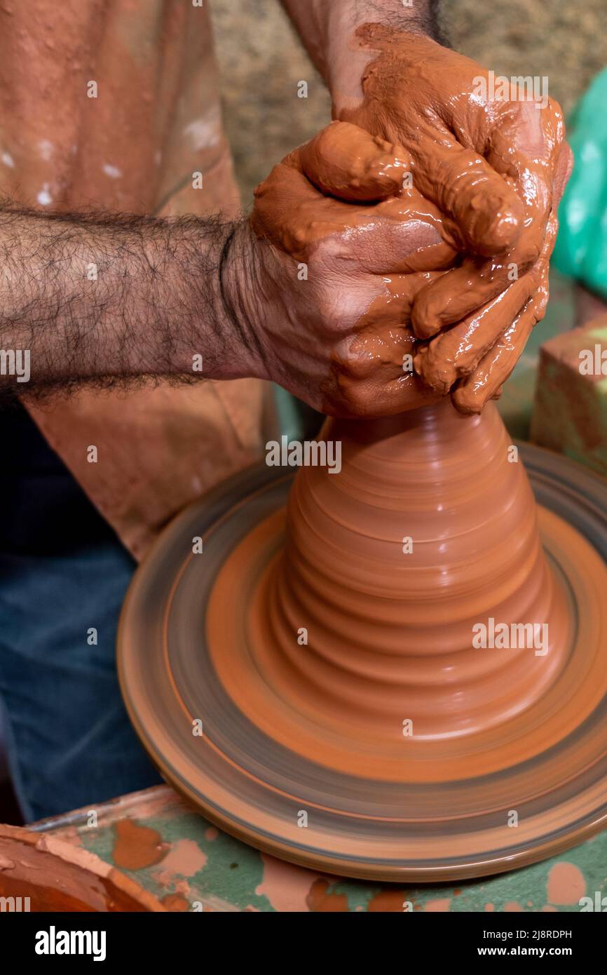 Mani di mestiere che fanno un vaso di creta. Le mani degli uomini  portoghesi. Potter al lavoro. Creazione di vasi in ceramica da argilla  fresca bagnata su ruota in ceramica. Creazione. Lavoro