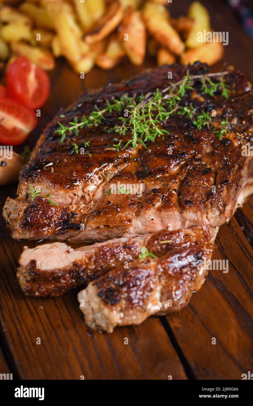 Bistecca di maiale fritta a fette su un tavolo di legno per servire Foto Stock